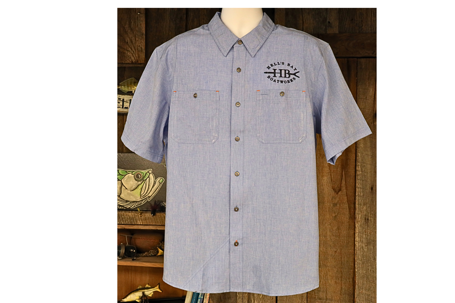 
                  
                    Light blue Hell’s Bay Orvis Tech Chambray short sleeve work shirt with button front, two chest pockets, and embroidered HB push pole logo.
                  
                