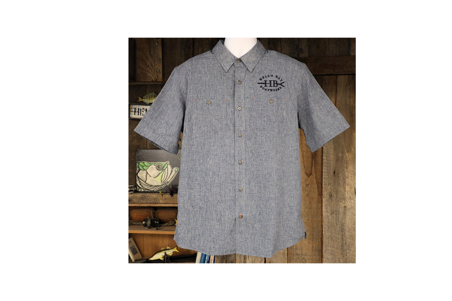 
                  
                    Light grey Hell’s Bay Orvis Tech Chambray short sleeve work shirt with button front, two chest pockets, and embroidered HB push pole logo.
                  
                