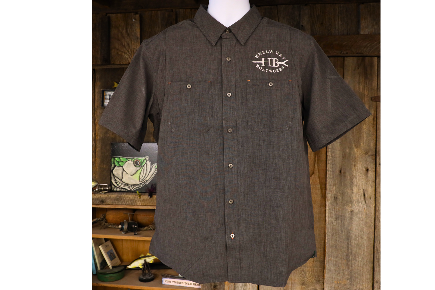 
                  
                    Dark brown Hell’s Bay Orvis Tech Chambray short sleeve work shirt with button front, two chest pockets, and embroidered HB push pole logo.
                  
                